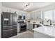 Modern kitchen features stainless appliances, gray cabinetry, quartz countertops, and ample counter space at 9625 Bighorn Way, Littleton, CO 80125