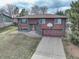 Charming two-story home featuring a brick and wood exterior, driveway, and front yard with a basketball hoop above the garage at 1505 S Zang Ct, Lakewood, CO 80228