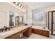 Bathroom with granite countertops, double sinks, soaking tub, and glass-enclosed shower at 3391 Prairie Vista Dr, Castle Rock, CO 80109