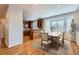 Bright dining area with hardwood floors, bay window, rug, and an island connecting to the kitchen at 3391 Prairie Vista Dr, Castle Rock, CO 80109