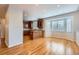 Bright open space with hardwood floors, bay window, and an island connecting to the kitchen at 3391 Prairie Vista Dr, Castle Rock, CO 80109