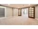 Spacious living room area with cozy carpeting and glass French doors at 3391 Prairie Vista Dr, Castle Rock, CO 80109