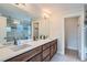 Modern bathroom featuring a large mirror, dual sinks, wood cabinets, and a glass-enclosed shower at 3643 Zuni St, Denver, CO 80211