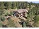 Aerial view of sprawling home with large decks, stone accents, and surrounded by lush greenery at 22759 Mountain Spirit Way, Indian Hills, CO 80454