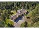 Aerial view of expansive home with a long driveway and lush landscaping in a serene, wooded setting at 22759 Mountain Spirit Way, Indian Hills, CO 80454