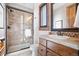 Bathroom featuring a glass-enclosed shower and a wood vanity with a framed mirror at 22759 Mountain Spirit Way, Indian Hills, CO 80454