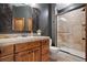 Bathroom showcasing a wood vanity, decorative mirror, and a tiled walk-in shower, blending style and functionality at 22759 Mountain Spirit Way, Indian Hills, CO 80454