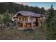 Expansive home with a rustic design and spacious outdoor living area nestled in a wooded hillside at 22759 Mountain Spirit Way, Indian Hills, CO 80454