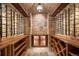 A wine cellar featuring stone walls and a tile floor with wooden wine racks on either side at 22759 Mountain Spirit Way, Indian Hills, CO 80454