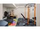 Well-equipped basement gym features padded flooring, bench with weights, and squat rack with cable system at 8211 E 128Th Pl, Thornton, CO 80602