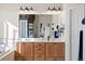 Bathroom featuring double sinks with wooden cabinets and large mirror at 8211 E 128Th Pl, Thornton, CO 80602