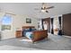 Bright main bedroom showcasing a ceiling fan, large window and gray carpet at 8211 E 128Th Pl, Thornton, CO 80602
