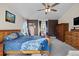 Comfortable bedroom featuring ceiling fan, gray carpet and brown accent wall at 8211 E 128Th Pl, Thornton, CO 80602