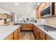 Bright kitchen with stainless appliances, wood cabinets and large countertops in an open floor plan at 8211 E 128Th Pl, Thornton, CO 80602