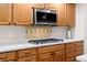 Close up view of wood cabinets, stainless microwave and gas range at 8211 E 128Th Pl, Thornton, CO 80602