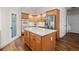 Kitchen with island, stainless appliances, wood cabinets and an adjacent pantry door at 8211 E 128Th Pl, Thornton, CO 80602
