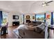 Bright and airy living room with hardwood floors, fireplace, vaulted ceiling, and picture windows at 8211 E 128Th Pl, Thornton, CO 80602