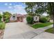 Charming single-story home with brick facade, manicured lawn, and large concrete driveway leading to a two-car garage at 3413 Boxelder Dr, Longmont, CO 80503