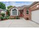 Front exterior showcasing brick facade, concrete driveway, and meticulously maintained landscaping including flower gardens and shrubs at 3413 Boxelder Dr, Longmont, CO 80503