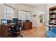 Bright office with hardwood floors, dual windows and desk space, and adjacent doorway to kitchen area at 3413 Boxelder Dr, Longmont, CO 80503