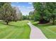 Scenic view of a winding concrete walking path through the lush, green community lawn at 3413 Boxelder Dr, Longmont, CO 80503