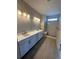 Modern bathroom with dual sinks, quartz countertops, and a marble tile shower at 251 Washington St, Erie, CO 80516