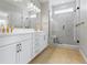 Bathroom with double vanity and a glass-enclosed shower with gold hardware at 251 Washington St, Erie, CO 80516