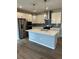 Modern kitchen featuring stainless steel appliances, a center island with seating, and stylish pendant lighting at 251 Washington St, Erie, CO 80516