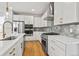 Gourmet kitchen featuring stainless appliances, white cabinetry, and elegant hardware at 251 Washington St, Erie, CO 80516