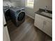 Efficient laundry room with front-loading machines, a sink, and cabinet space at 251 Washington St, Erie, CO 80516