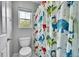 A full bathroom offers a tub with a shower and a toilet behind a playful dinosaur curtain at 9270 107Th E Pl, Commerce City, CO 80640