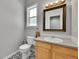 Charming half bathroom with patterned floors, wood vanity, and ample lighting at 9270 107Th E Pl, Commerce City, CO 80640