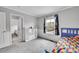 A bedroom offers flexible space with a bed, shelving, a window, and carpeted floor at 9270 107Th E Pl, Commerce City, CO 80640