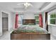 A well-lit bedroom features a wooden bed frame, ceiling fan, and natural light from the windows at 9270 107Th E Pl, Commerce City, CO 80640