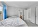 This bedroom features carpeted floors, a window with blue curtains, and access to a bathroom at 9270 107Th E Pl, Commerce City, CO 80640
