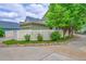 Home featuring well-maintained landscaping with lush green trees and a white picket fence at 9270 107Th E Pl, Commerce City, CO 80640