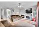 Cozy living room featuring a fireplace, modern TV, and comfortable brown reclining sofa at 9270 107Th E Pl, Commerce City, CO 80640