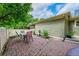 Brick patio with an outdoor dining set, surrounded by a white fence and trees at 9270 107Th E Pl, Commerce City, CO 80640