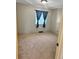 Empty bedroom features neutral carpet and window with dark blue curtains at 6492 Simms St # A, Arvada, CO 80004