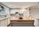 Bright kitchen featuring island with butcher block top, white cabinets, and modern lighting at 6492 Simms St # A, Arvada, CO 80004
