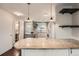 Updated kitchen with granite countertops, modern pendant lights, and a breakfast bar at 6492 Simms St # A, Arvada, CO 80004