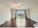 Light-filled living room featuring hardwood floors, ceiling fan, and sliding glass doors to backyard at 6492 Simms St # A, Arvada, CO 80004