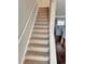 Carpeted stairway leads to open kitchen with center island and hardwood floors at 6492 Simms St # A, Arvada, CO 80004