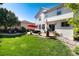 A spacious backyard with a concrete patio, outdoor seating, and a lush green lawn at 2880 Breezy Ln, Castle Rock, CO 80109