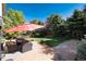 A spacious backyard with a concrete patio, outdoor seating, and a lush green lawn at 2880 Breezy Ln, Castle Rock, CO 80109