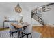 Open dining room with hardwood floors, a rustic table and a view of the staircase at 2880 Breezy Ln, Castle Rock, CO 80109
