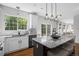 A spacious kitchen features a marble breakfast bar, white cabinets, stainless appliances, and large window overlooking backyard at 2880 Breezy Ln, Castle Rock, CO 80109
