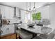 Bright kitchen features a marble island with seating, white cabinets, stainless steel appliances, and a large window at 2880 Breezy Ln, Castle Rock, CO 80109