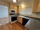 A well-lit kitchen featuring wood cabinets, laminate countertops, and modern appliances at 16180 E Flora Pl, Aurora, CO 80013