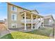 Back exterior view of a home with a covered deck, white pillars and steps at 10052 Isle St, Parker, CO 80134